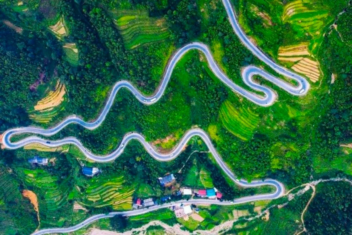 Toàn cảnh trên cao con đường đèo uốn lượn qua những sườn đồi xanh mướt ở Cao Bằng.