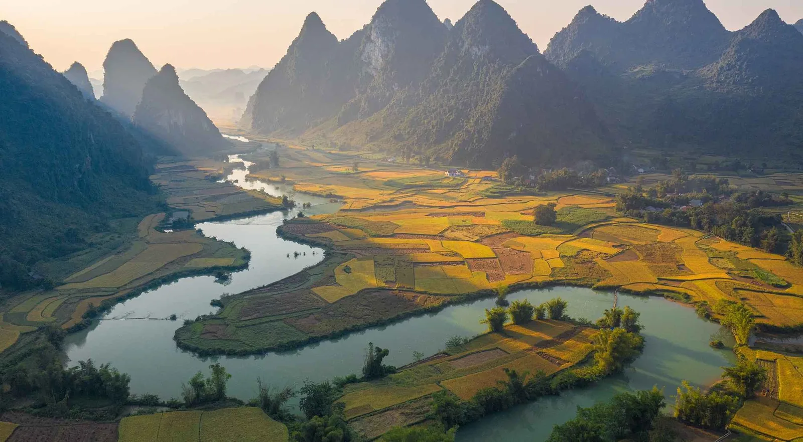 Dòng sông uốn lượn qua những cánh đồng lúa vàng dưới chân núi đá vôi hùng vĩ ở Cao Bằng.