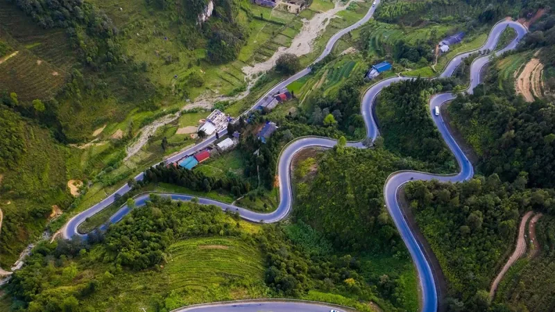 Góc nhìn từ trên cao ghi lại con đường núi ngoằn ngoèo uốn lượn qua những đồi xanh gần Cao Bằng.